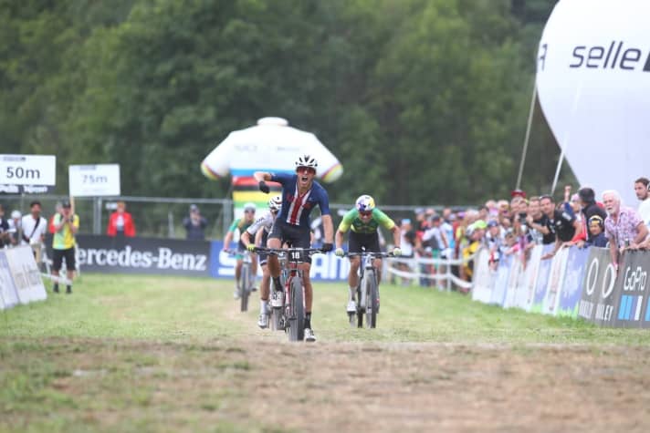   Christopher Blevins celebrates gold just a few metres before the finish line. Behind him, Brandl and Avancini are still fighting for the other medals.