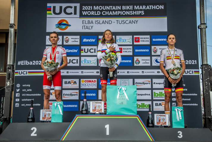   Little Mona Mitterwallner in the rainbow jersey at the top of the podium. Silver once again goes to Maja Wloszczowska (left), bronze to Spain's Natalia Fischer.