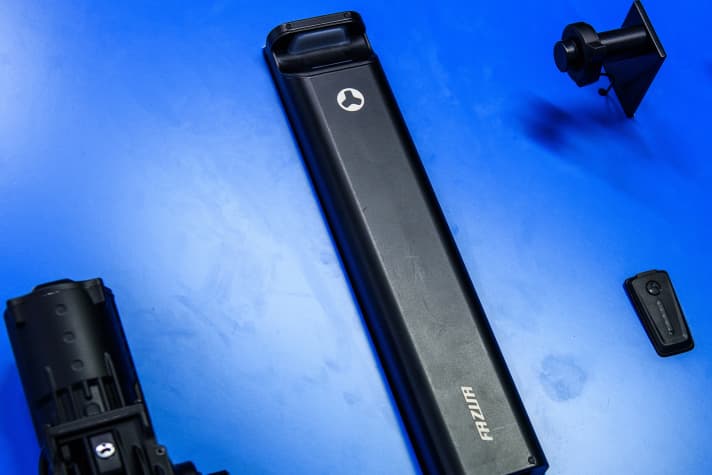   Das Gesamtsystem Fazua Ride 60 besteht aus Motor, 430-Wattstunden-Akku, der Ring-Control für den Lenker und der LED-Hub (unten rechts), die im Oberrohr Platz findet. Sie zeigt über farbige LEDs die gewählte Unterstützungsstufe und den Akkustand an und lässt sich zum Vorbau hin leicht nach oben anwinkeln. So wird ein USB-C-Port freigelegt um Smart-Geräte direkt über den Akku zu laden.