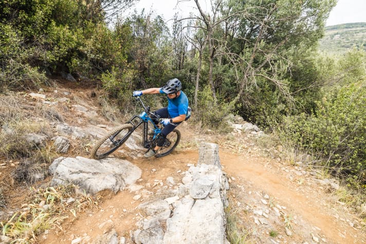 Stefan dreht das Bike weiter ein und überrollt mit viel Schwung sogar den vor ihm stehenden Felsen.