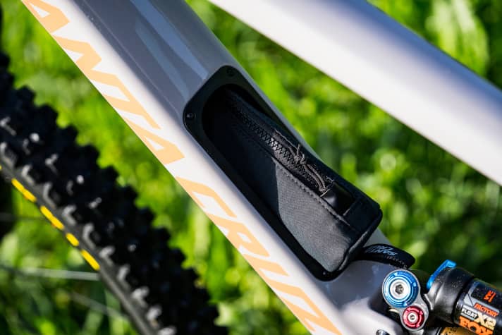 The integrated frame storage compartment conceals a small tool bag and a separate bag for the spare inner tube.