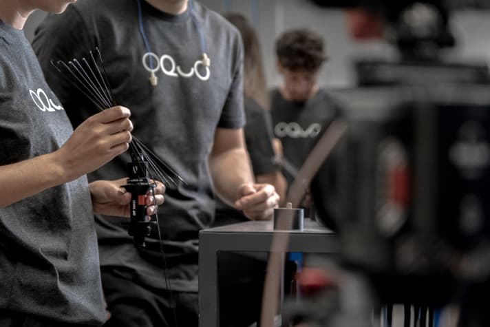 Before the spoking robot takes over, the spokes are threaded into the hub flanges by hand.