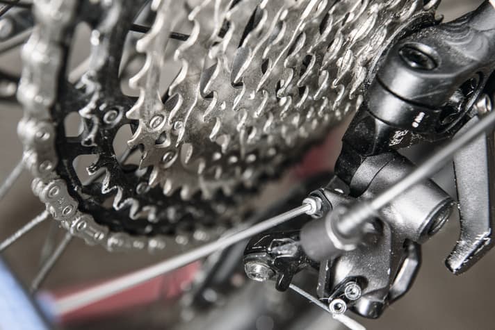   Damit alles möglichst reibungslos läuft, sollte man mit der Umschlingungsschraube am Schaltwerk (hier Shimano) die Distanzen zwischen oberem Schaltröllchen und Kassette einstellen.