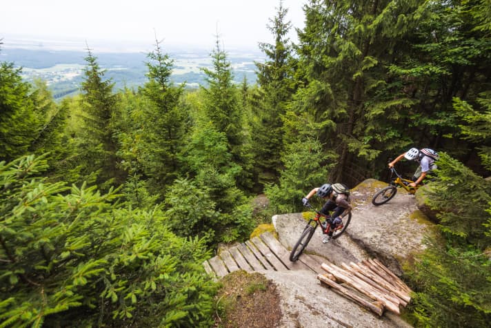 Test riders Thomas and Max race the test bikes over a specially designed uphill flow trail.