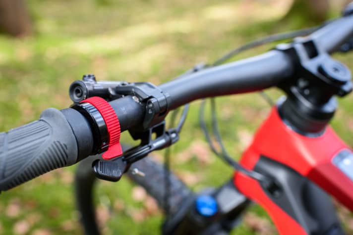 Push me! The fiery red, ball-bearing mounted boost button looks high-quality and is easy to reach. Only when things get rooty is the grip on the handlebars unsteady when the lever is pressed.