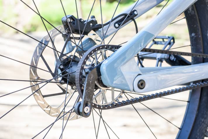 Statt schwerem Schaltwerk und Kassette sitzt am Hinterrad nur eine filigrane Riemenscheibe und ein schlanker Halter. Das hält die ungefederte Masse am Heck gering.