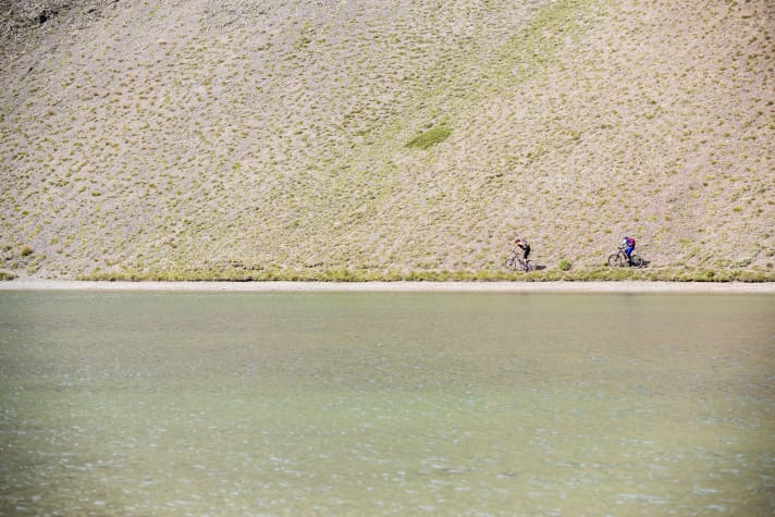 Wie eine Fatamorgana schimmert er plötzlich in den Steppenhügeln: der Lago di Sette Colori. Besonders im Abendlicht changiert sein Wasser in unterschiedlichsten Farben.