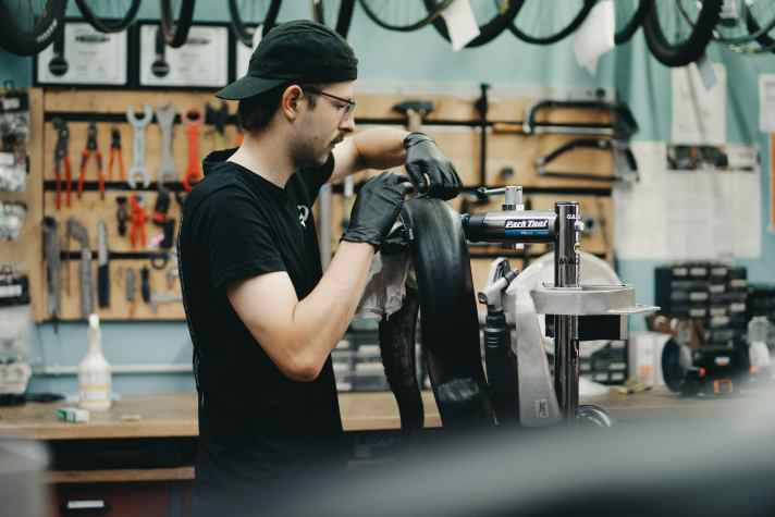 Paul from TriShop Saar patches the tyre with a piece of inner tube. It is then remounted tubeless - and lasts until the end.