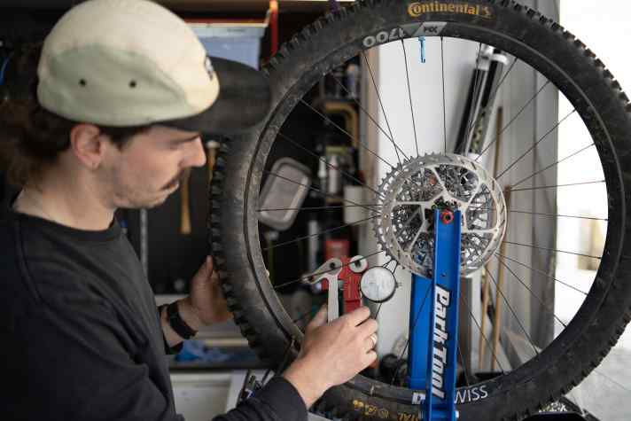 Here, Lukas is still focussed on the tensiometer - calm on the outside, but bubbling on the inside. Because what looks like meticulous tinkering is actually frustration management: Having to re-centre the rear wheel after such a short mileage is really annoying.