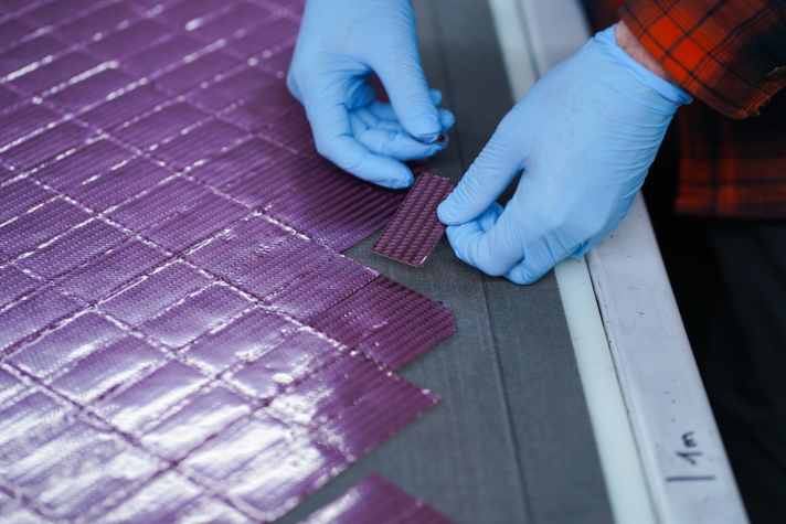 Les fabricants de cadres reçoivent les préimprégnés de carbone sous forme de grands tapis. Ils les découpent ensuite en fonction des besoins individuels.