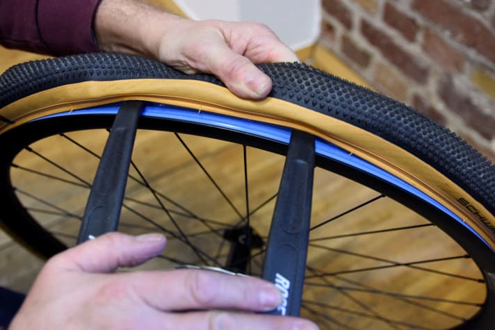 Tyre mounting: Clamp the tyre lever between the tyre bead and the rim so that it lifts the tyre bead slightly and then hold it firmly with one hand.