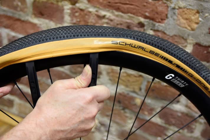 Place the second tyre lever under the tyre bead a hand's width next to the first tyre lever and then lever the tyre over the rim flange with both levers at the same time.