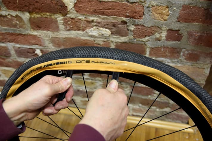 Tyre fitting: Use the tyre lever to pull the inner tube onto the rim.