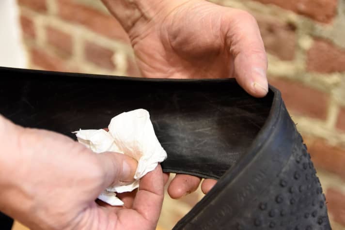 Ein kleines Stück Haushaltswatte zwischen Daumen und Zeigefinger nehmen und langsam durch den Mantel ziehen, um nach Fremdkörpern zu suchen.