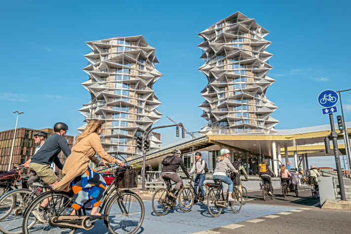 The journey to work becomes a sightseeing tour: cyclists ride past the city's architectural highlight, the Kaktus Towers.