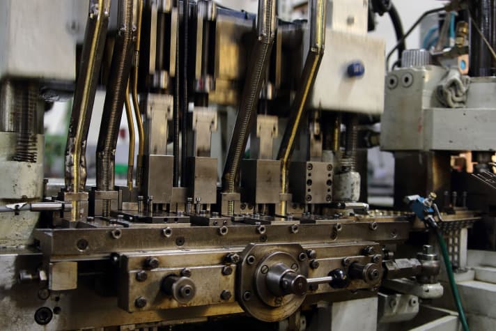 With loud clicking, rattling and tapping in a fast rhythm, the individual components are finally joined together in this machine to form a chain and riveted.