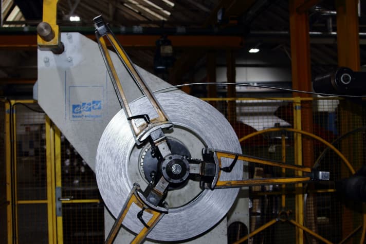 La matière première utilisée pour les chaînes provient presque entièrement de la région productrice et transformatrice d'acier et des environs. Ci-dessus, l'une des bandes d'acier de plusieurs centaines de mètres de long dans laquelle sont découpés les huit, c'est-à-dire les maillons intérieurs et extérieurs.