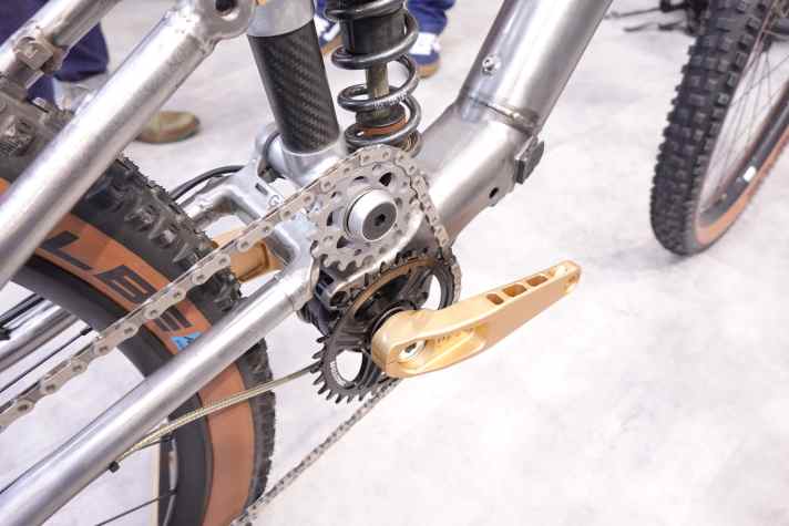 To avoid pedal kickback, the high pivot point of the rear triangle is combined with chain deflection.