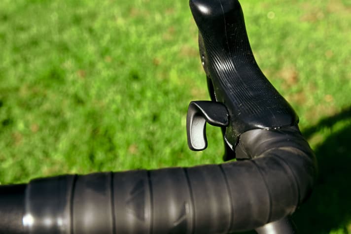 The small lever for upshifting with the thumb is difficult to reach from the brake lever and restricts the positions on the top link.