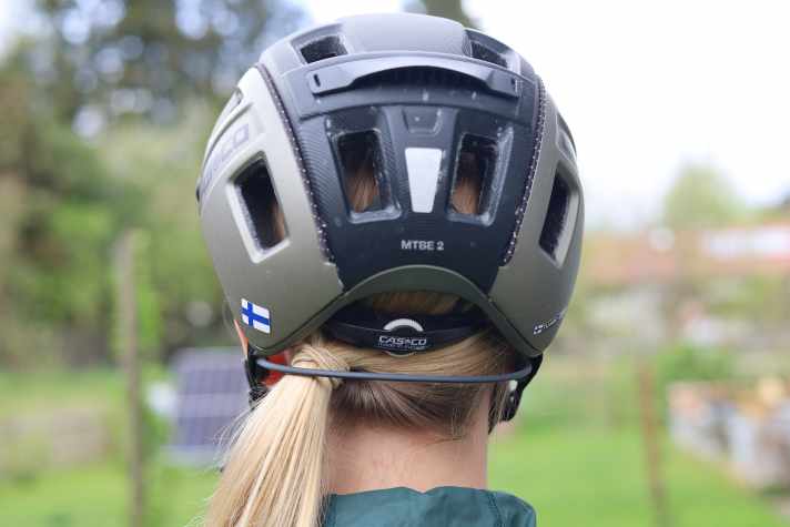 The Shokz OpenRun Pro 2 uses a neck strap. There can be space problems with helmets that are pulled down low and in combination with pigtails.
