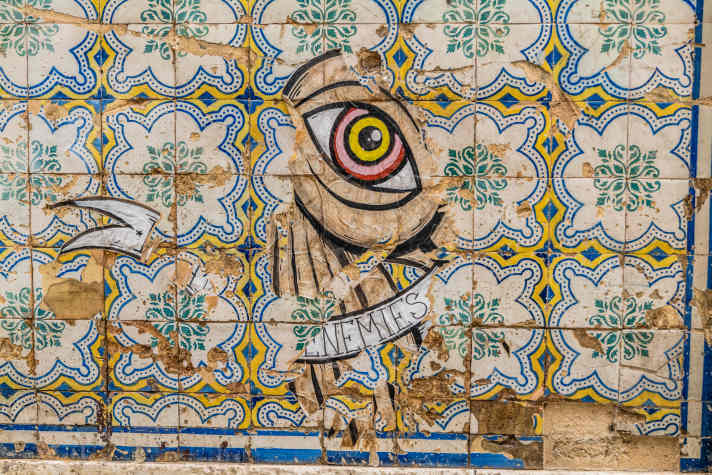 Street art: a new work of art is created from a damaged tiled wall