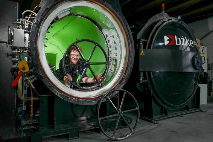 Our reporter poses with the first production-ready 32-inch Ahead Biturbo X bike in the autoclave. He was allowed to add a few layers of carbon himself.