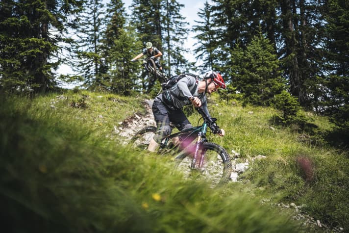 Während manches E-MTB in dieser Federwegsklasse mit Enduro-Qualitäten prahlt und gerne durch die Luft fliegt (hinten im Bild), bleibt das Samedi 29 Trail eher mit beiden Rädern auf dem Boden. Schwierige Trails meistert es dennoch.
