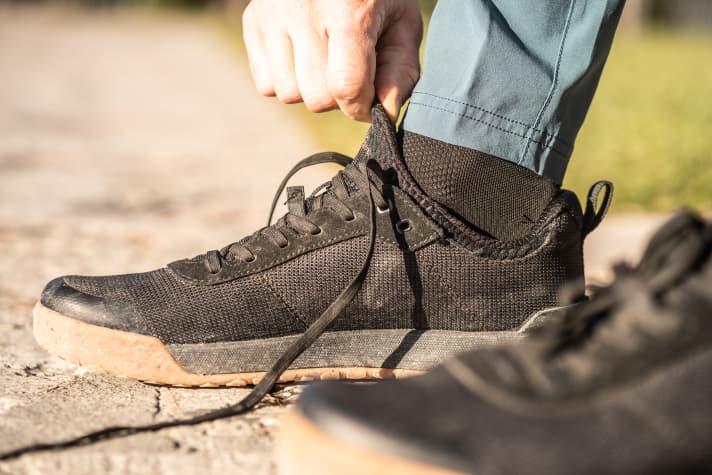 Der schlauchartige Einstieg sorgt für einen engen Sitz des Schaftes rund um den Knöchel. Das flexible Material ist sehr komfortabel. Die exponierte Frontpartie ist außen gegen Abrieb geschützt, eine integrierte, steife Zehenbox schützt die Knochen gegen Anstoßen.