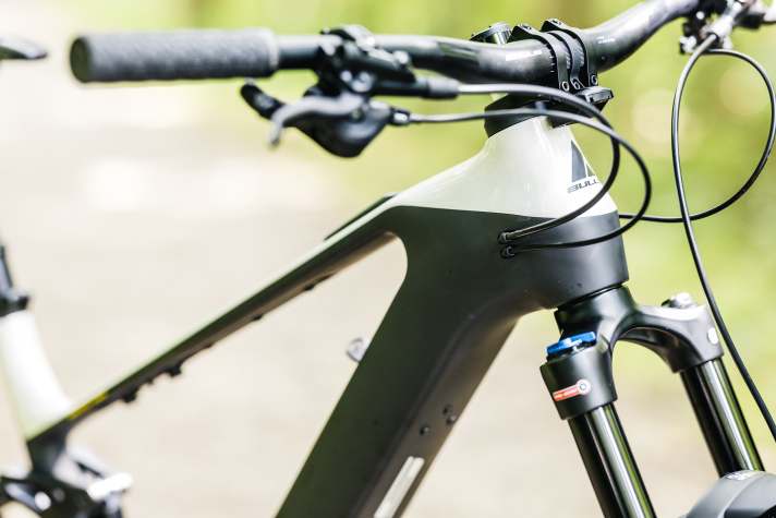 The cables run classically behind the head tube into the frame, while the electric cables are integrated into the headset.