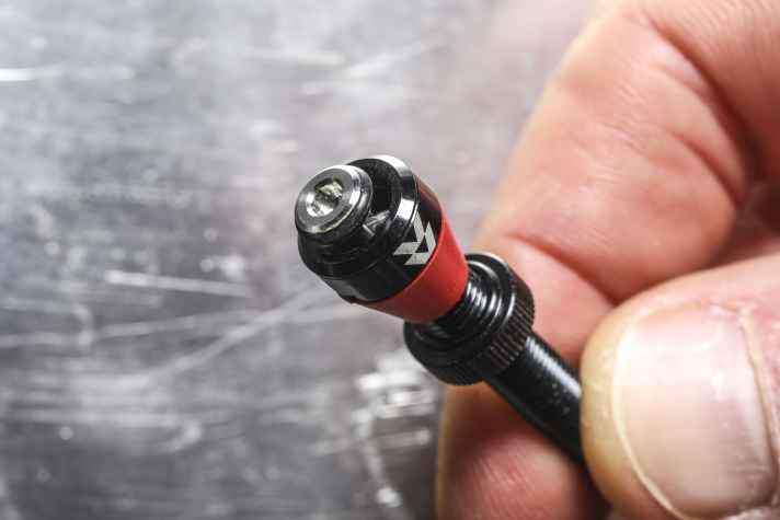 Kein Ventilkern, dafür ein durchgängiger Stift, der das Ventil beim Festschrauben der Staubkappe von unten verschließt.