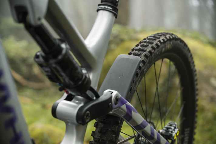 Ein Fender soll den gröbsten Schmutz von Lagern und Gelenken fernhalten. In der Unschärfe ist außerdem das asymmetrische Design mit quer liegendem Dämpfer zu erkennen.