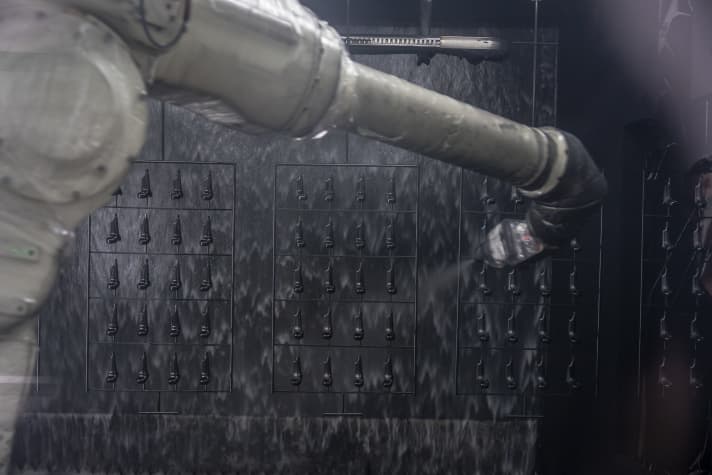 The robot takes over the painting. A waterfall absorbs vapours and excess paint.