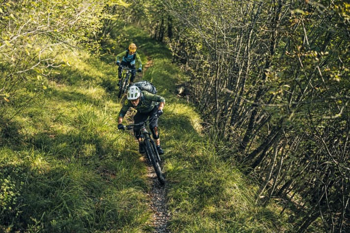 Nicht mehr ausgesetzt und sanft rauscht der Trail mit uns durch die Bergwiesenflanken zum Seeufer hinunter.
