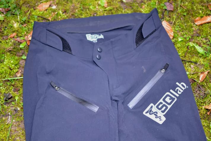 The SQ-Pants One10 have Velcro fasteners on the waistband for width adjustment, 2 pockets and a large reflective brand logo.