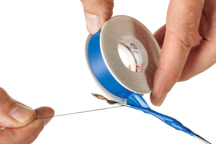 Lay a sturdy twisted yarn (or shift cable) about 10 cm long parallel to the end of the cable and glue it tightly.