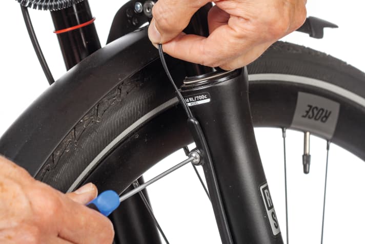 Legen Sie das Dynamokabel vollends frei. An Federgabeln wird das Kabel meist unter einer verschraubten Leiste entlang des Holms geführt.