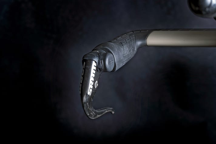   Schalten per Funk: Frodeno wird vom Komponentenhersteller SRAM gesponsert. Sein Rad ist mit der kabel­losen Funkschaltung eTap ausgestattet. Wegen der speziellen Griffe am Basislenker erwies sich die Montage der eTap aber als kompliziert. Um die Schalttasten zu montieren, mussten im 3D-Druckverfahren spezielle Kontaktflächen angefertigt werden, die auf die Bremshebel aufgeklebt wurden. In der Serie bietet Canyon das Rad derzeit nur mit der elektrischen
 	Di2-Schaltung von Shimano an.