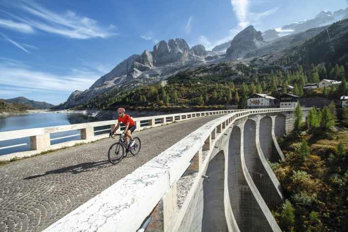 Cycle tour Dolomites: At the reservoir, at the foot of the Marmolada, the Passo Fedaia is reached.