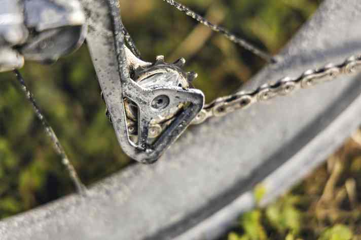 Am Antrieb des Rennrads von Remco Evenepoel haftet eine dicke Kruste aus Öl und Schmutz