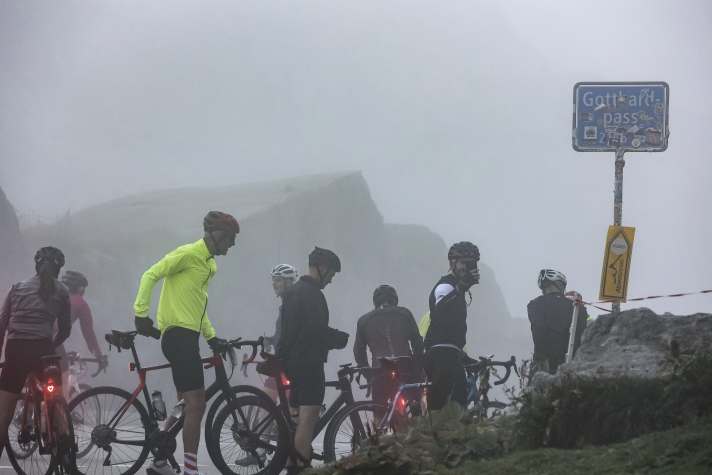 Le brouillard et l'humidité au Gothard pèsent sur le moral des cyclistes, mais ils roulent en groupe et se motivent mutuellement.