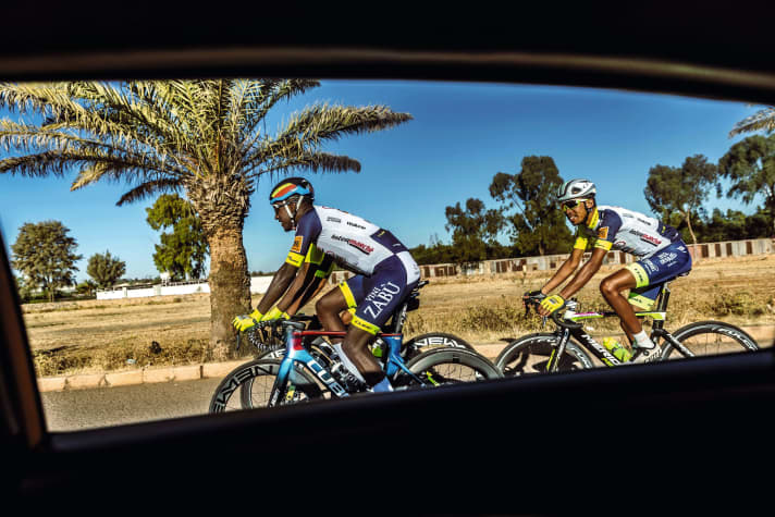 Lors de sa visite au pays, Girmay (à gauche) apporte des vêtements de cyclisme à ses amis en guise de cadeau.