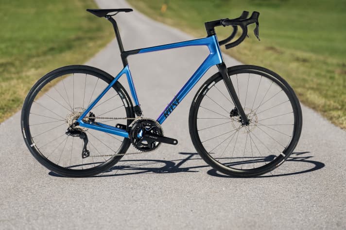 Das Rose Reveal Four 105 Di2 >> <a href="https://www.awin1.com/cread.php?awinmid=11768&awinaffid=471469&clickref=T+Rose+Reveal+Four+105+Di2&ued=https%3A%2F%2Fwww.rosebikes.de%2Frose-reveal-four-disc-105-di2-2716193%3Fproduct_shape%3DShiny%2BAurora%252FMatt%2BBlack%2B%2528Effektlack%2529" target="_blank" rel="noopener noreferrer nofollow">hier erhältlich</a>*