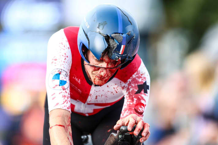 Stefan Küng chute peu avant l'arrivée et termine la course couvert de sang et le casque brisé.