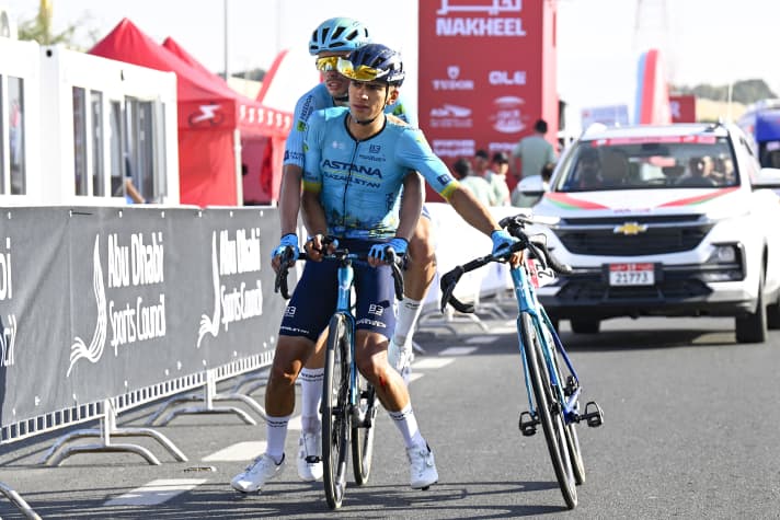 Michele Gazzoli (back) helps his Astana team-mate Harold Tejada to the finish line after the latter was involved in a mass crash on the home straight