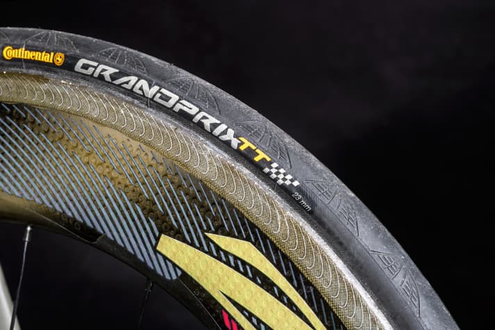  Spezialgummi: Beim Rollwiderstand ist der Zeitfahrreifen GrandPrix TT von Con­tinental kaum zu schlagen. Aerodynamisch ist allerdings der Bestseller GrandPrix 4000 S2 einen Tick besser. Durch das Profil in der Lauffläche löst sich der Wind schneller ab, was gegenüber der glatten Lauffläche des TT ein bis zwei Watt Ersparnis bringt. Exklusiv für Frodeno fertigte Conti deshalb einen Spezialreifen, der den Aufbau des GrandPrix TT mit dem Profil des GrandPrix 4000 S2 vereint. Kaufen kann man diesen Reifen nicht.