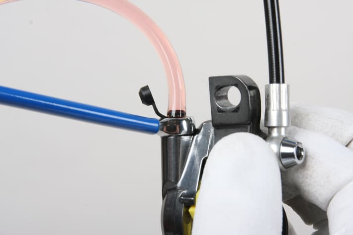 Schieben Sie den gefüllten Schlauch auf die Entlüftungsschraube des Bremssattels der Rennrad Scheibenbremse