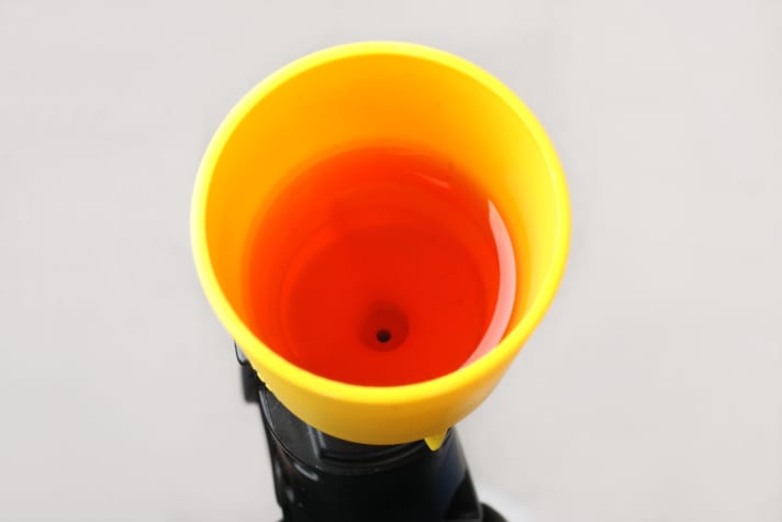 Öl tritt nun oben am Trichter aus. Drücken Sie so lange, bis keine Luftblasen mehr austreten.