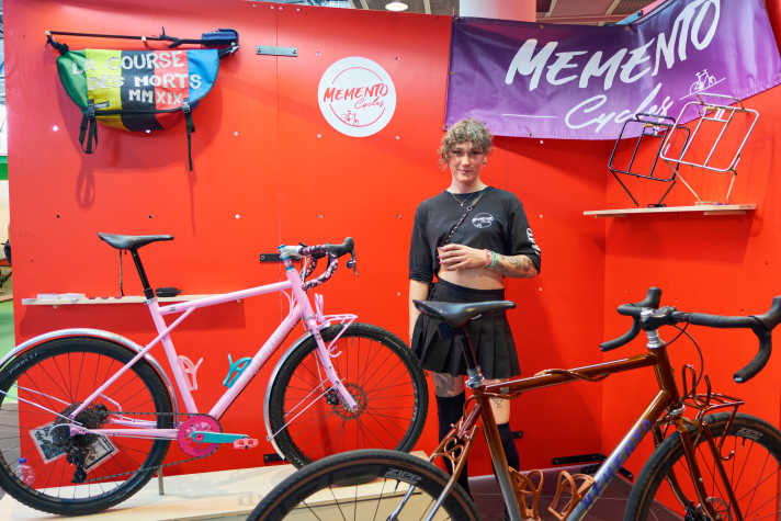 Éliane Trudeau von Memento Cycles zwischen den Rädern. Details wie das dünne Metallrohr, das sich am vorderen Rad um das Oberrohr windet, lassen die Augen daran kleben bleiben.