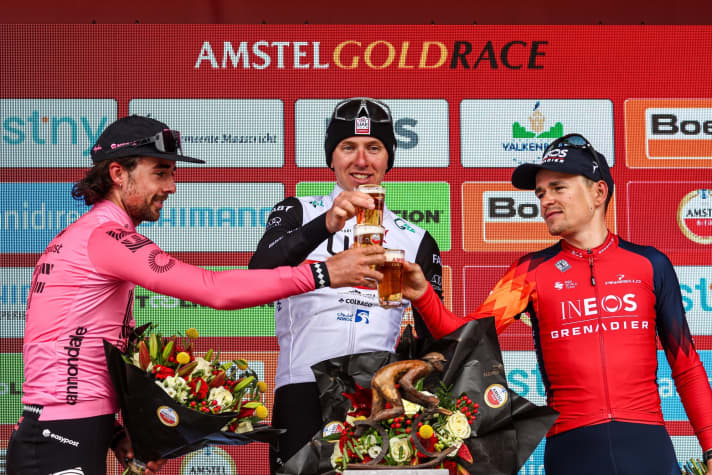 Amstel Gold Race 2023: Sieger Tadej Pogacar (Mitte), Ben Healy (Platz zwei/links) und Tom Pidcock (Rang drei/rechts) stoßen gemeinsam auf ein Bier an