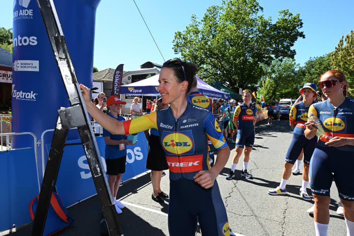 Amanda Spratt zeigt das Jersey für 2024 bei der Einschreibkontrolle vor der 1. Etappe der Tour Down Under